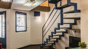 A modern interior with a staircase, a dining area with a glass table, and a red chair. - Catania City Apartment by Wonderful Italy (Catania)