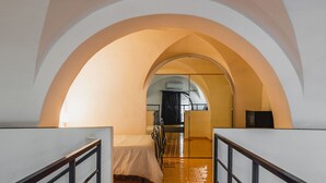 A narrow hallway with an arched ceiling, leading to a room with a bed and a window. - Catania City Apartment by Wonderful Italy (Catania)