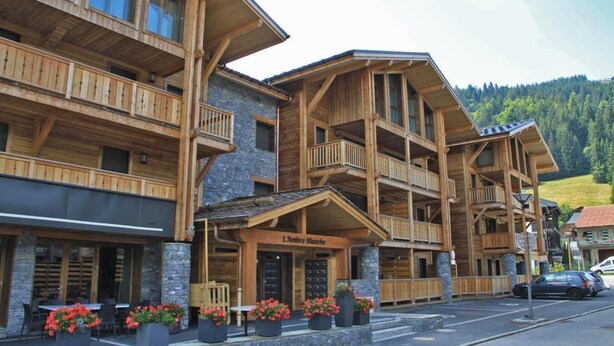 A multi-story wooden building with balconies, a stone facade, and a sign reading "L'Ambre Blanche". - Wifi, 200m from ski slopes, 1st floor, balcony, 65m², Les Gets (Les Gets)