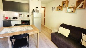 A compact living space with a kitchenette, a dining table with a chair, and a sofa. - Balcony, 28m², Les Gets (Les Gets)