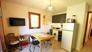 A compact living space with a dining area, a washing machine, and a refrigerator. - Balcony, 28m², Les Gets (Les Gets)