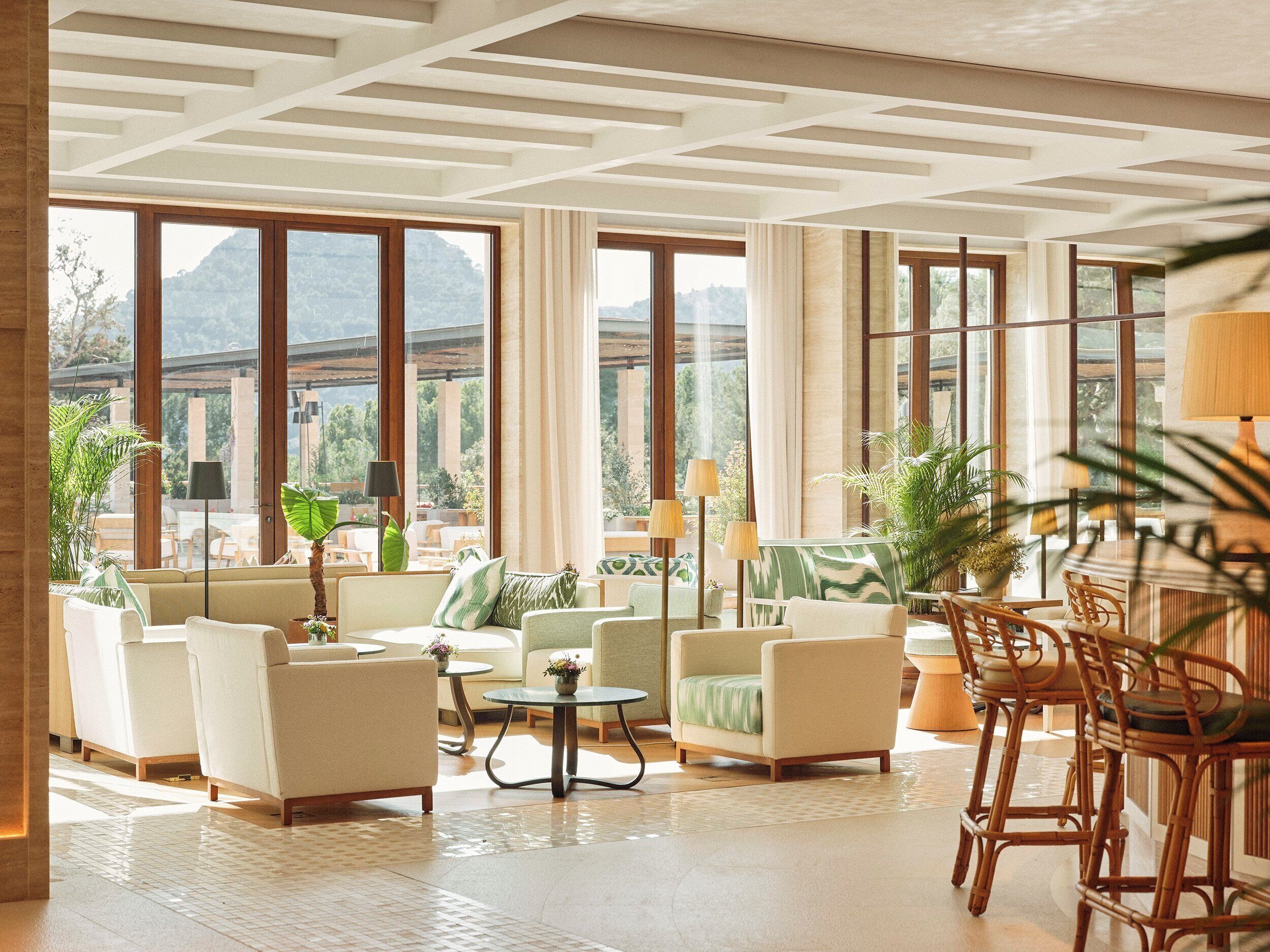 A spacious living room with large windows, comfortable seating, and a view of the outdoors.