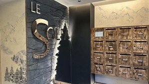 A reception area with a stone wall, a large 'LE' sign, and a wooden storage unit with multiple compartments. - 3rd floor, sauna, balcony, tv, ski locker, 115m², Vars (Vars)