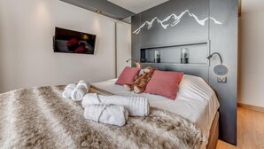 A modern bedroom with a large bed, fluffy rug, and a wall-mounted TV. - 200m from ski slopes, 5th floor, view mountain, balcony, ski locker, 50m², Tignes (Tignes)