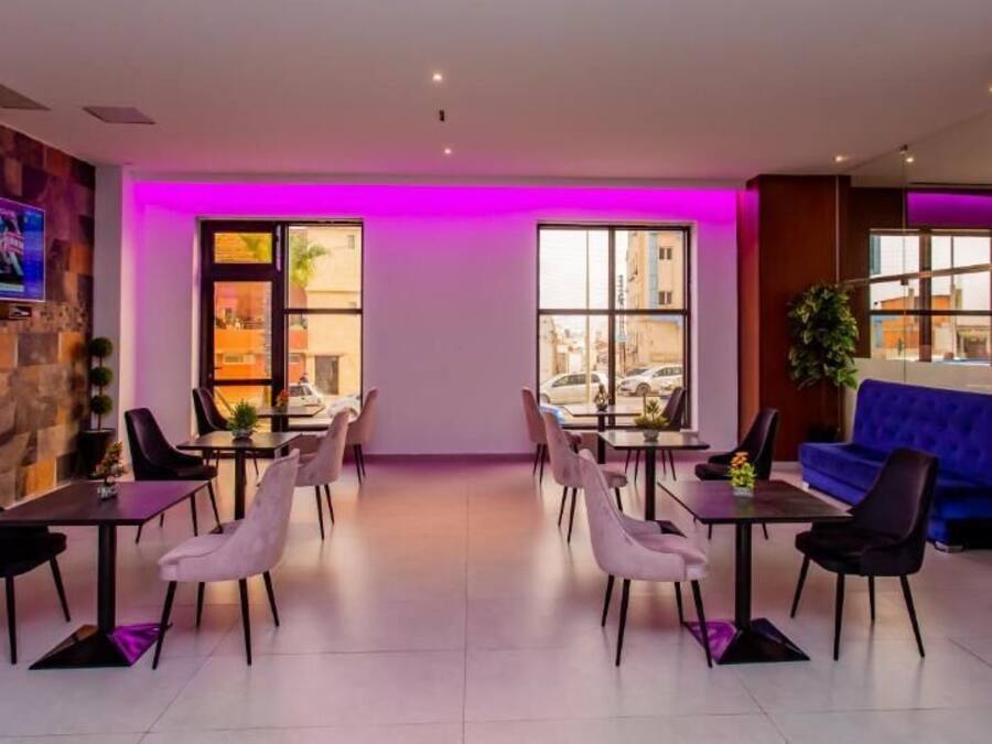 A modern dining area with a stone wall, a flat-screen TV, and a blue sofa.