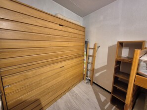 A room with a wooden wardrobe, a ladder, and a wooden shelf unit. - La Mongie Apartment for 8 People, Right on the Slopes   (Bagnères-de-Bigorre)