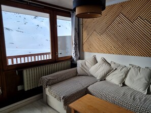 A cozy room with a wooden bench, a patterned sofa, and a view of a snowy landscape through a window. - La Mongie Apartment for 8 People, Right on the Slopes   (Bagnères-de-Bigorre)
