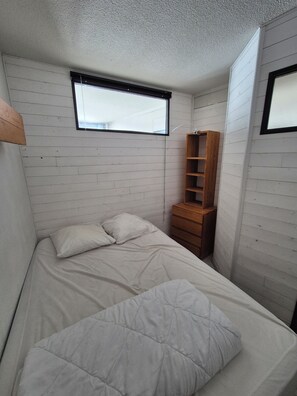 A small, compact room with a bed, a wooden dresser, and a window. - La Mongie Apartment for 8 People, Right on the Slopes   (Bagnères-de-Bigorre)
