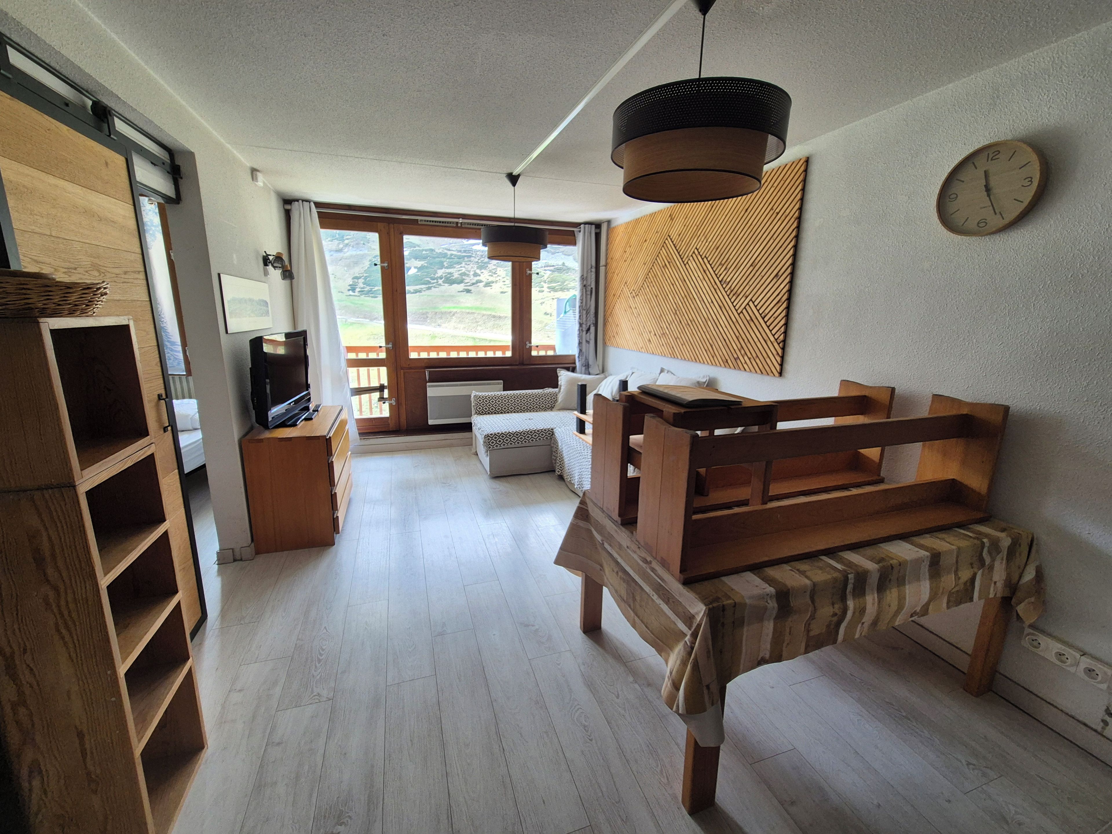 A spacious room with a wooden bench, a television, and a view through a large window.