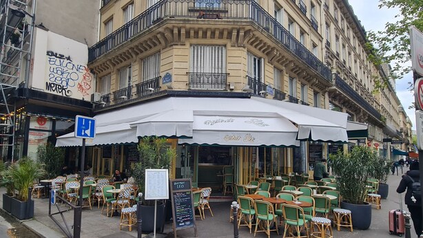 A cafe with outdoor seating, a white awning, and a sign for 'Bistro Leo'. - Urban Flat 156 - Yves Flat in Montorgueil (París)