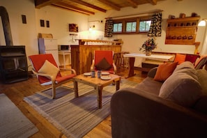 A cozy living room with a fireplace, wooden furniture, and a dining area.