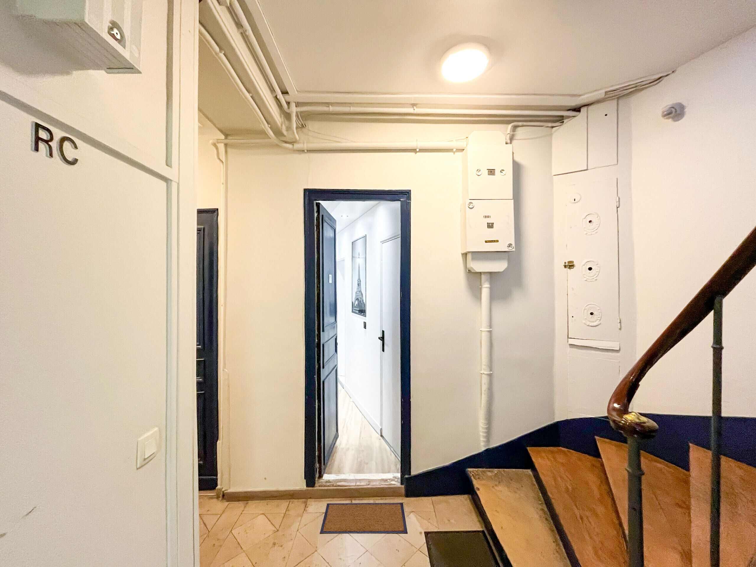 A hallway with a door leading to a stairwell.