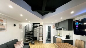 Eine moderne Wohnung mit Wohnzimmer, Küche und Treppe.