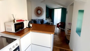 Cozinha compacta com micro-ondas, fogão e um pequeno espaço de refeições.