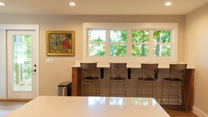 A dining area with a white table and four metal chairs. There is a window with a view of trees and a door with a glass panel. - Mammoth Cave, WKU, Barren River Lake, Travel Sports, Corvette (Bowling Green)