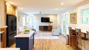 A modern kitchen with a large island, wooden cabinets, and a built-in refrigerator. - Mammoth Cave, WKU, Barren River Lake, Travel Sports, Corvette (Bowling Green)