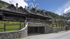 Un edificio de estilo chalete tradicional con fachada de piedra, balcones de madera y entrada de piedra.