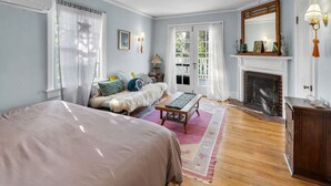 Une chambre avec un grand lit, un canapé, une cheminée et une vue sur l’extérieur.