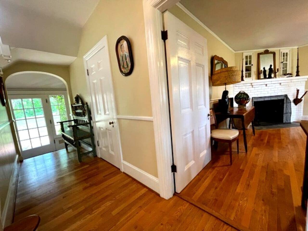 A spacious living room with hardwood flooring, a fireplace, and a dining area with a table and chairs.