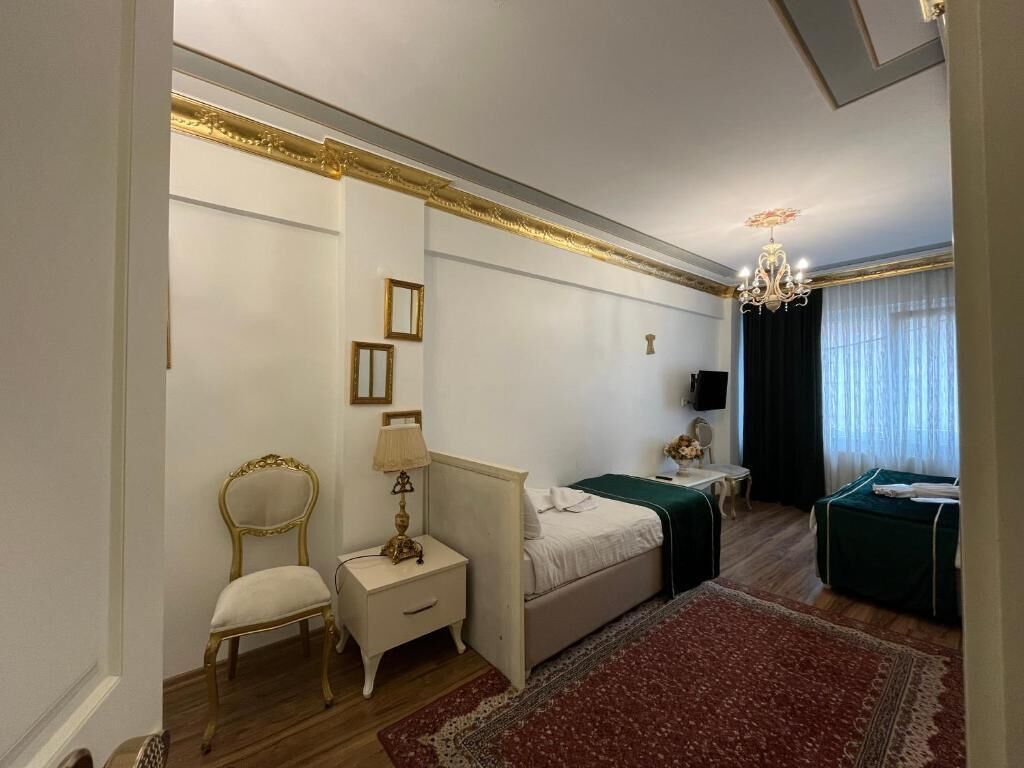 Une chambre à coucher comprenant un lit, une table de chevet, une chaise et une petite table avec une lampe.