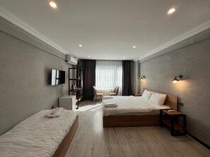 A hotel room with two beds, a desk, a chair, a TV, and a window with curtains. - Le Safran Hotel (Istanbul)