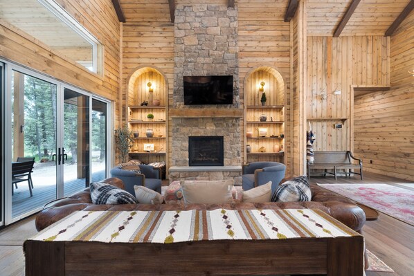 Relax in this cozy living area with a comfortable sofa, stone fireplace, and flat-screen TV.