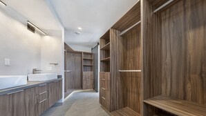 A modern bathroom with a large mirror, a sink, and wooden cabinetry. - Casa Lukaz Penthouse private rooftop (San José del Cabo)