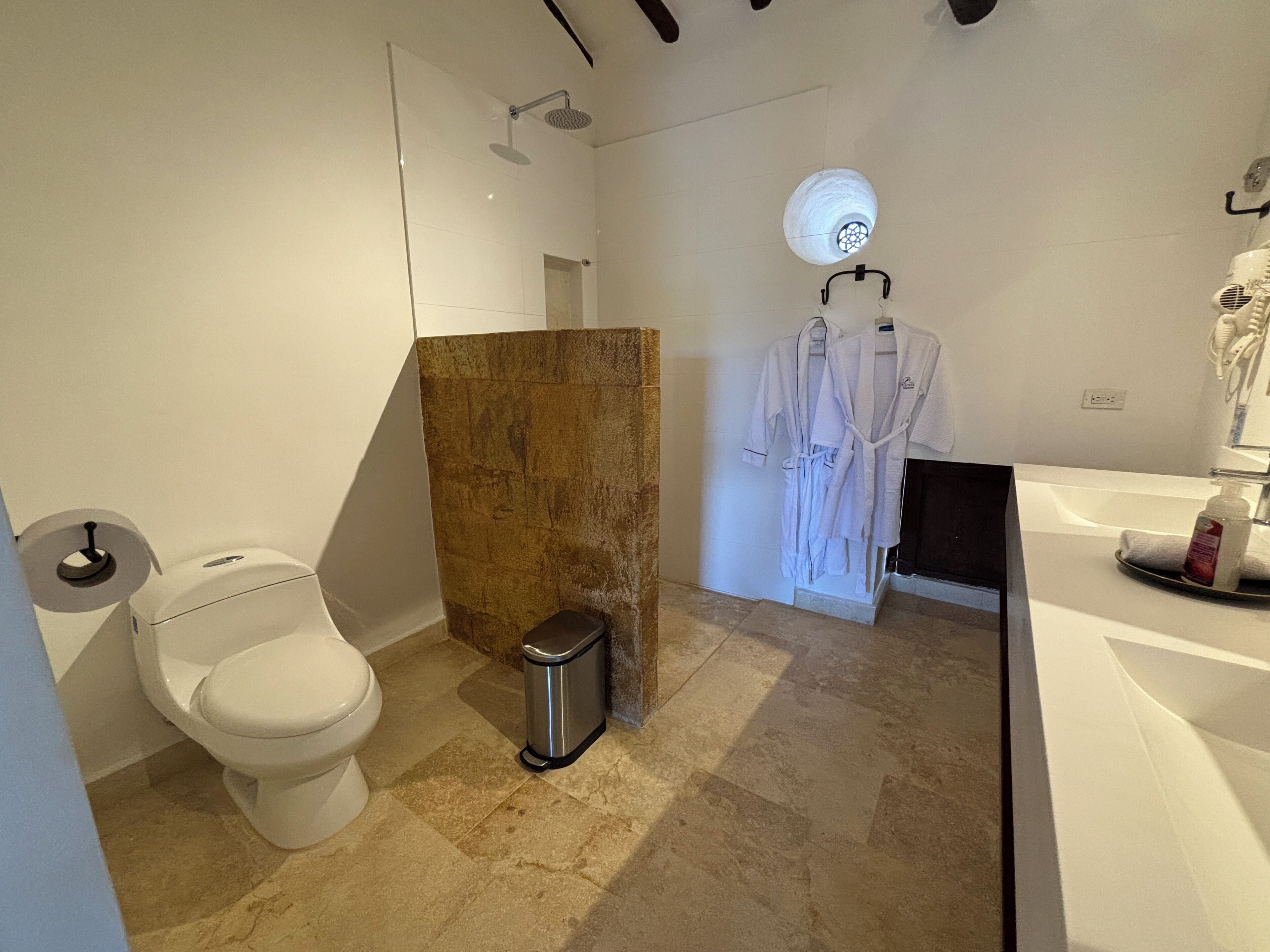 A modern bathroom with a toilet, shower, and sink.