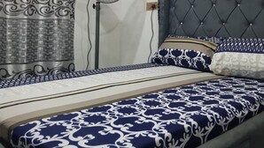 A bedroom with a bed, a standing fan, and curtains. - Lagos - 1bed - Sleeps 2 - Aircon - Free Parking (Lagos)