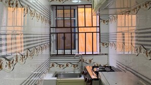 A compact kitchen with a window, a sink, and a stove. - Lagos - 1bed - Sleeps 2 - Aircon - Free Parking (Lagos)
