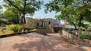 A hotel entrance with a stone facade, a reception desk, and a sign for Bharat Tourist Resort. - Barbet Tourist Resort (Sohna)