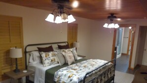 Une chambre à coucher avec un lit, des lampes de chevet et un ventilateur de plafond.