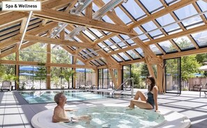 An indoor swimming pool with a wooden ceiling and glass panels, surrounded by lounge chairs and a view of greenery.