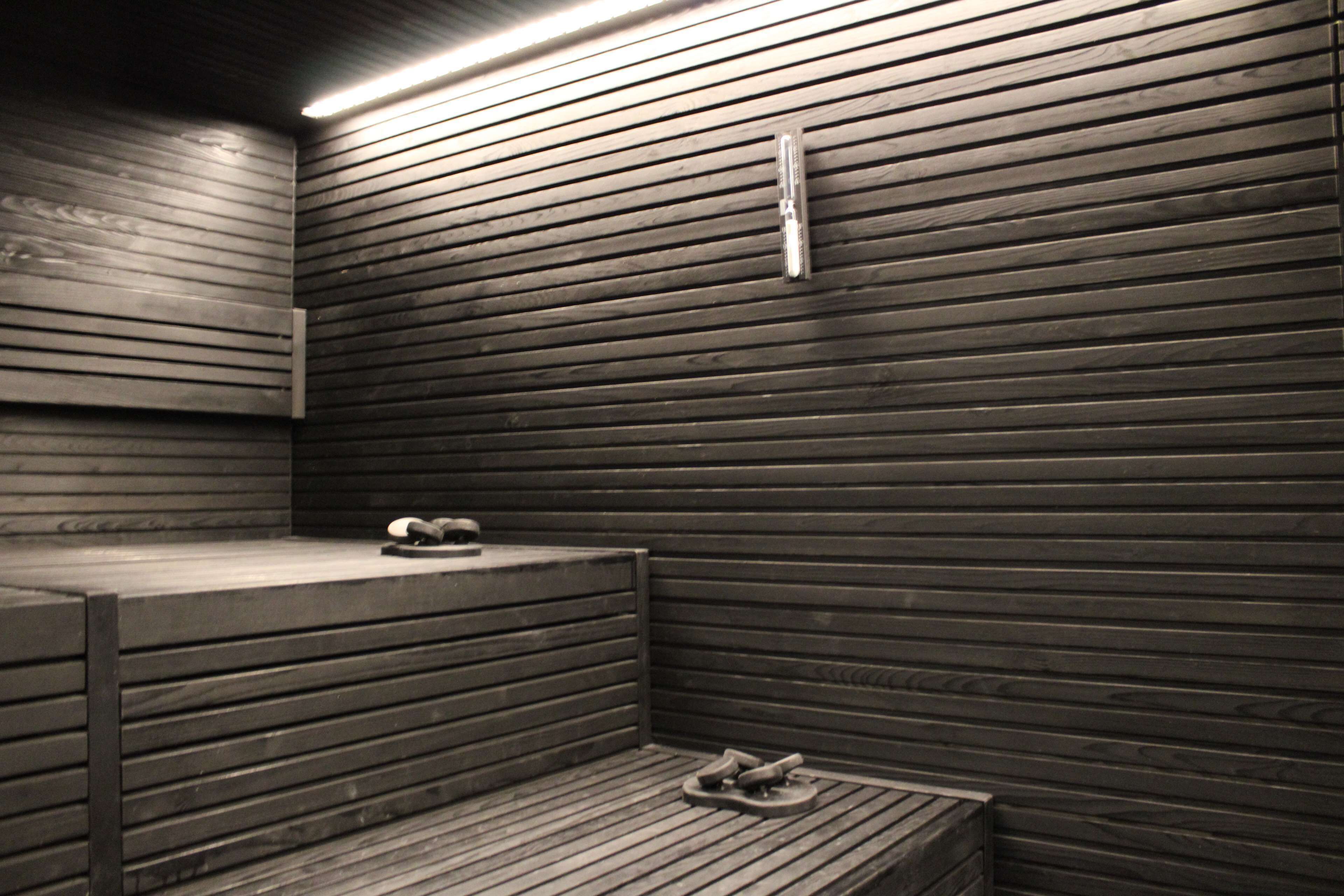 Una sauna con listones de madera en las paredes y bancos.