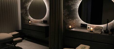 A modern bathroom with two sinks, a large mirror, and a toilet.