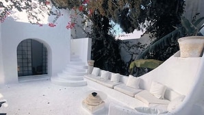 A white interior with a sofa and a small table, surrounded by white walls and a staircase. - Dar Essaroual Hammamet (Hammamet)