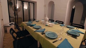A dining room with a table set for six, featuring blue plates and yellow tablecloths. - Dar Essaroual Hammamet (Hammamet)
