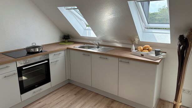 A modern kitchen with a skylight, a stove, an oven, and a sink. - Zentrales Neues, Modernes Apartment. Schneller Zugang Mittels Code-schloss (Herne)