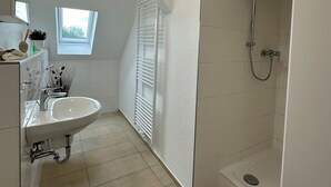 A modern bathroom with a white sink, vanity, and shower. - Zentrales Neues, Modernes Apartment. Schneller Zugang Mittels Code-schloss (Herne)