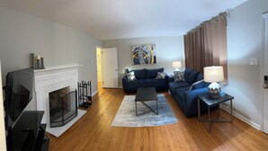 A living room with a fireplace, a sofa set, a coffee table, and a lamp. - Durham Vacation or Work Rental (Durham)