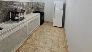 A compact kitchen with a white refrigerator, a stove, and a sink. - 2.simple, Sobre, Proche Mosquée et Belle Plage (Marsa Ben M'Hidi)