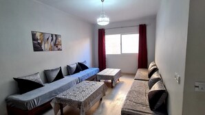 A living room with a sofa set, a coffee table, and a dining table. - 2.simple, Sobre, Proche Mosquée et Belle Plage (Marsa Ben M'Hidi)