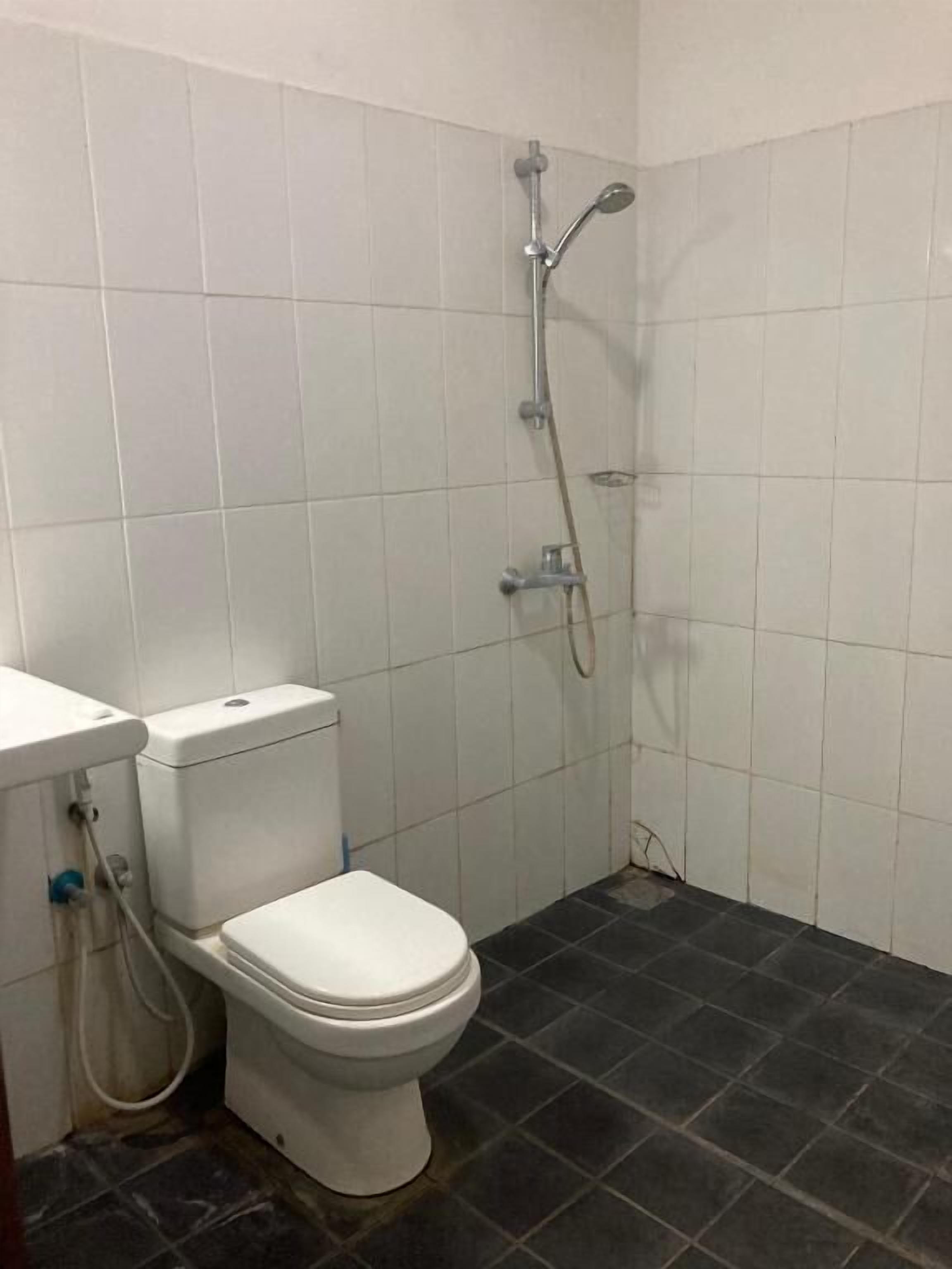 Un baño pequeño con inodoro, ducha y paredes de azulejos.