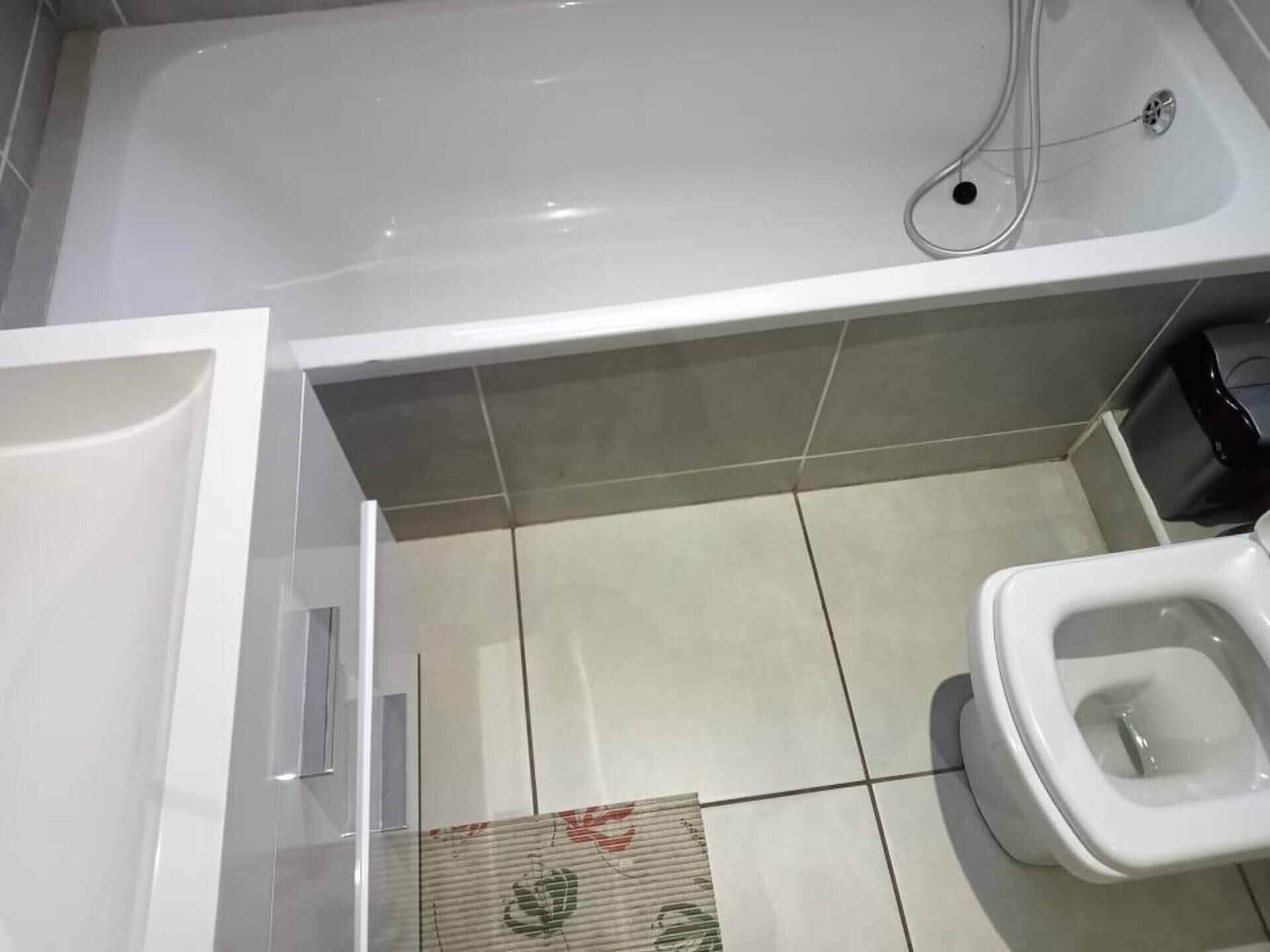 Egy modern fürőszoba, amelyben kád, WC és zuhanyzó található.