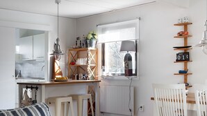 A compact living space with a kitchenette, a dining area, and a seating area with a sofa and chairs. - Semesterboende på Öland (Kalmar län)