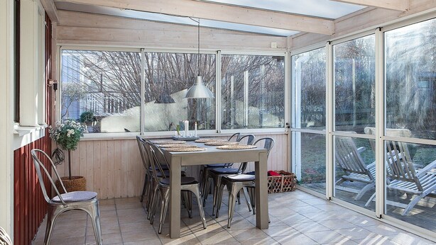 A conservatory with a dining table, chairs, and a hanging lamp. - Semesterboende på Öland (Kalmar län)