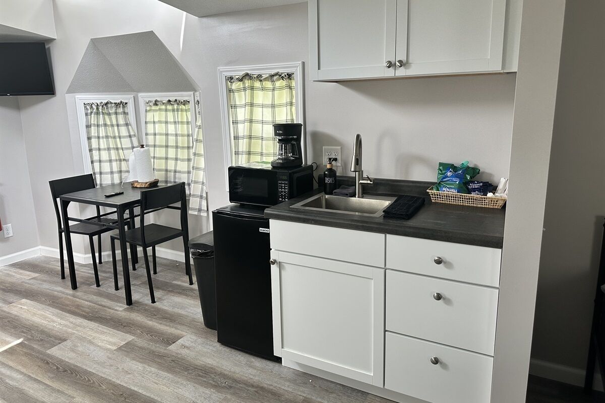 Coffee/tea maker, fridge, microwave, dining table