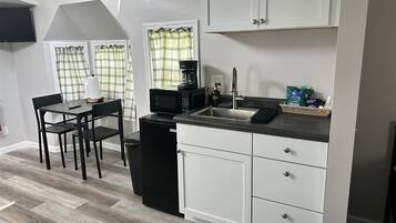 Coffee/tea maker, fridge, microwave, dining table