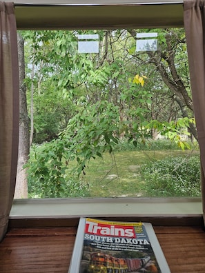 A window with a magazine titled 'Trains South Dakota' on a wooden surface. - Train caboose with open floor plan, high ceilings & modern airy feel (Hanna City)