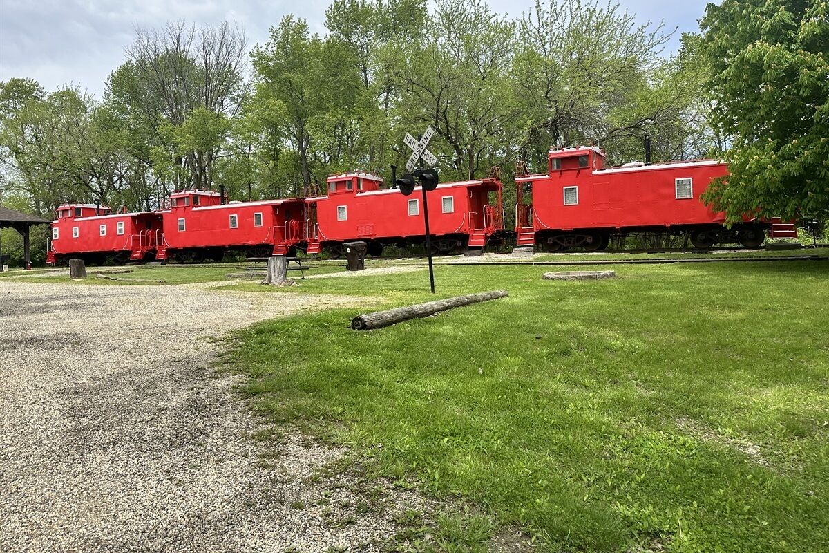 A red train car with a caboose and a caboose with a small cabin.